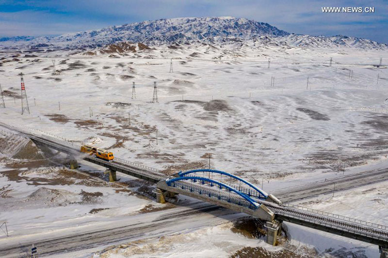 Photo aérienne prise le 21 janvier 2021 montrant un chasse-neige des voies ferrées en fonctionnement dans la zone venteuse de Maytas, le long de la voie ferrée Karamay-Tacheng, dans la région autonome ouïghoure du Xinjiang (nord-ouest de la Chine). (Hu Huhu / Xinhua)