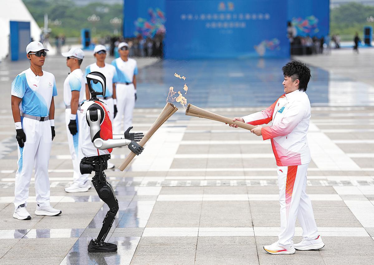 Yu Yang, médaillée d’or olympique de badminton, allume la flamme depuis celle portée par le robot humanoïde Kuavo le 3 novembre, lors du relais de la flamme organisé à Shenzhen, dans la province du Guangdong (sud de la Chine), pour les 15es Jeux nationaux. (Jiang Han / Xinhua)