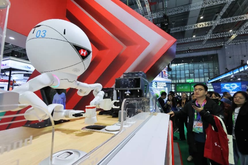 Un barista robotisé prépare du café pour les visiteurs dans la zone d’exposition des services lors de la 8e édition de la foire China International Import Expo à Shanghai, le 8 novembre 2025. (Photo/Tang Ke)